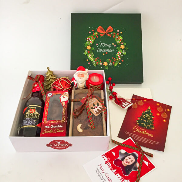 Christmas Gifts Hamper Filled with the Sparkling grape juice,Santa candle,plum cake, card, greeting card, Christmas decor items. All beautifully packed in a gifts hamper XMAGB009