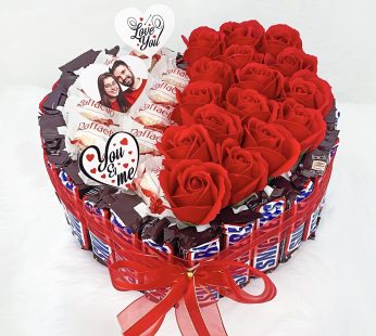 Tasty heart shaped Valentines day chocolates hamper basket with gorgeous red roses, a customized picture and lovely wishes.